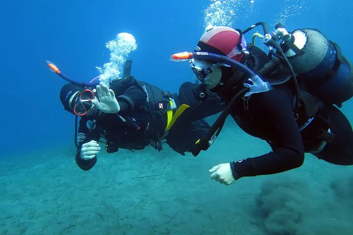 Diver over volcanic rock on a Santorini scuba diving experience, Santorini Greece