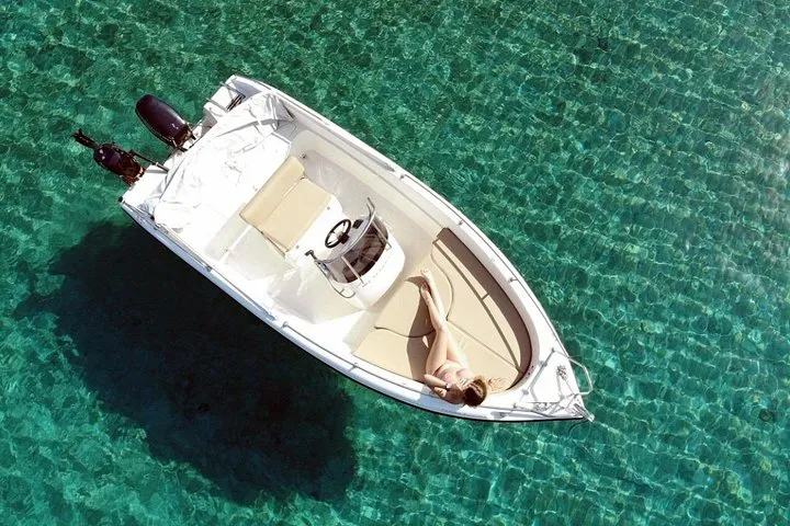 Small motorboat off the Vlychada cliffs on a licence-free Santorini boat rental, Santorini Greece