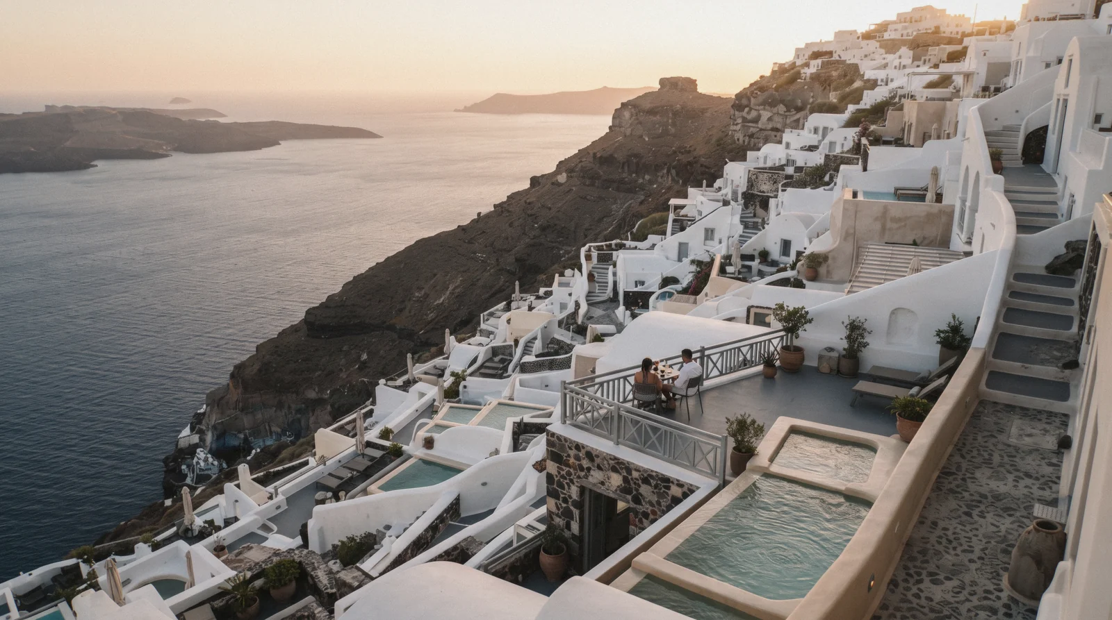Cave-house terraces stepping down the caldera cliff in Imerovigli at 19:00, where to stay in santorini, Santorini Greece